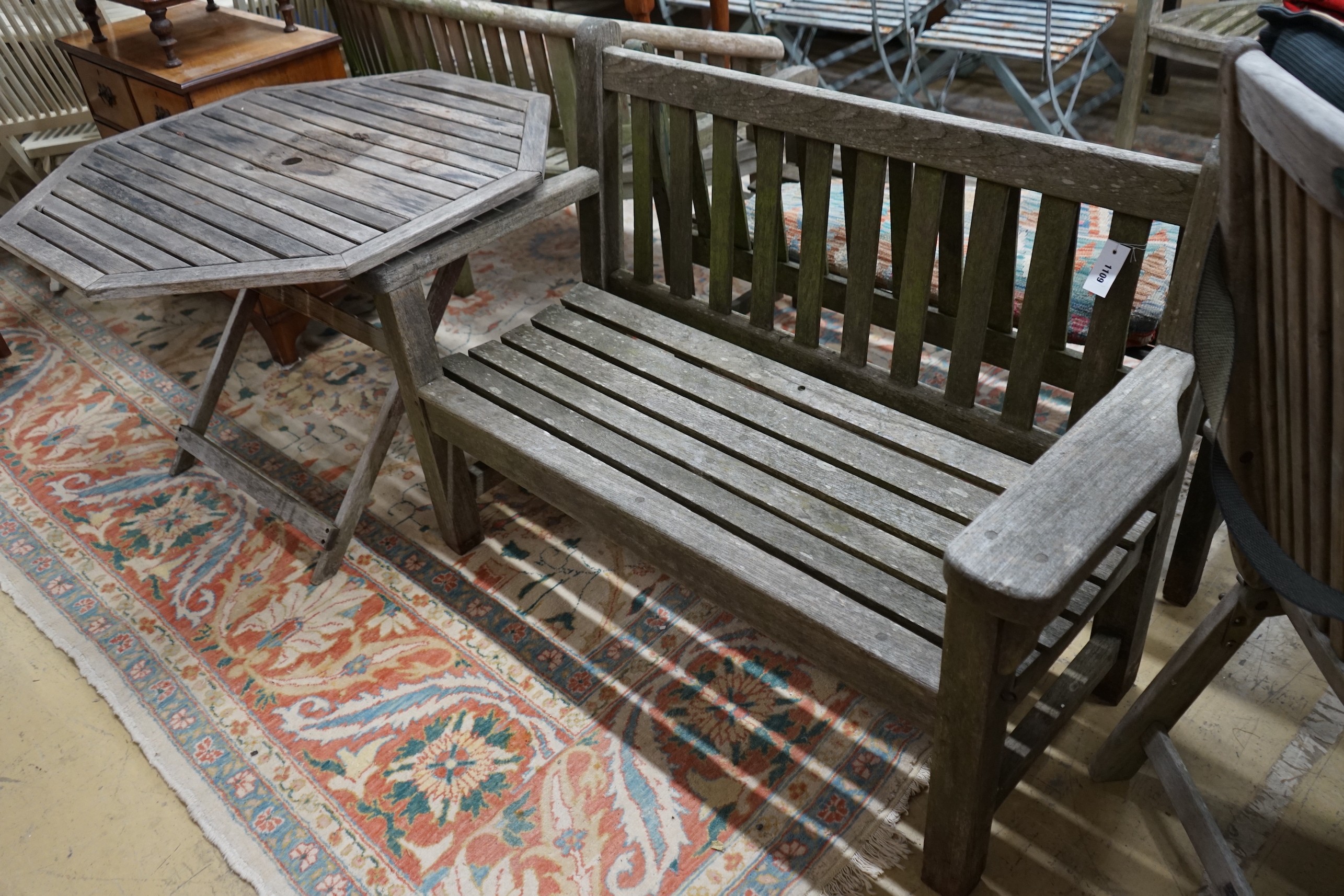 A weathered teak garden bench and an octagonal garden table, width 100cm, height 69cm